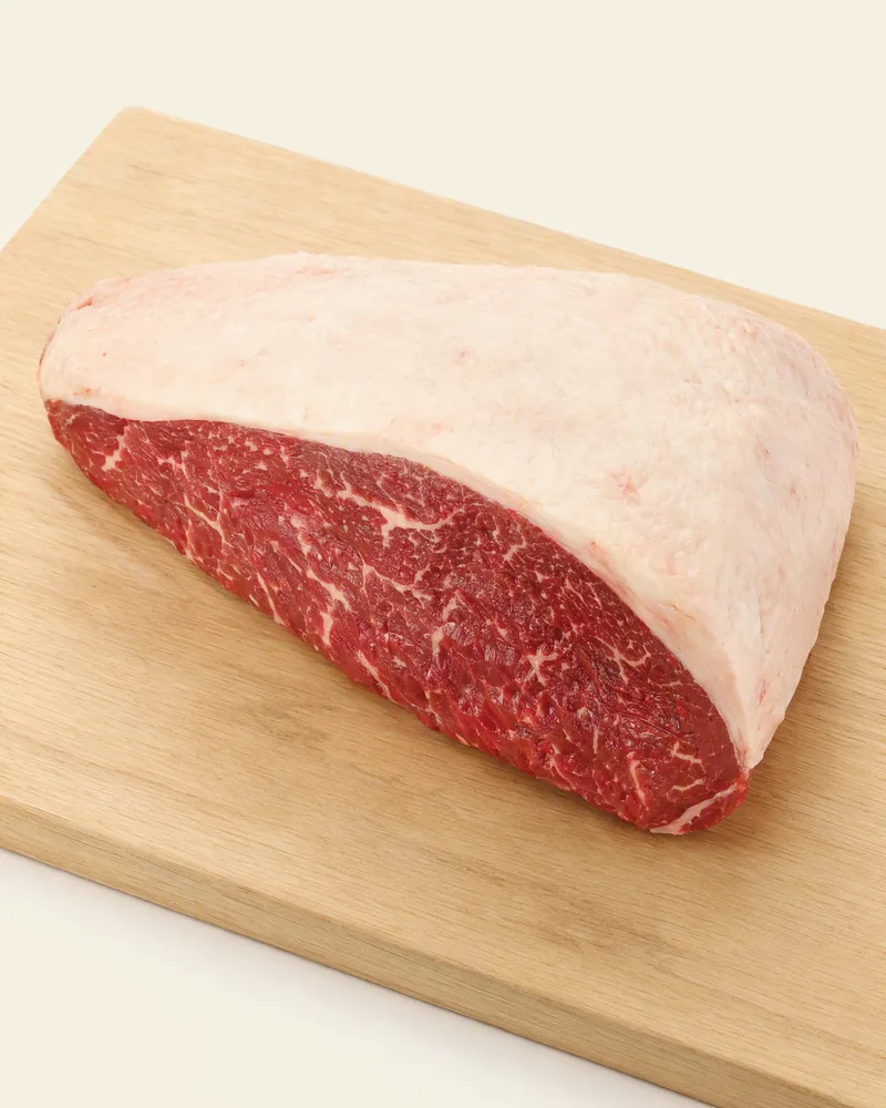 Picanha crua inteira, formato triangular, com capa de gordura branca sobre a carne vermelha