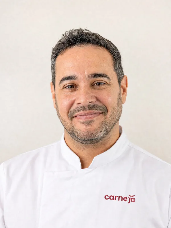 Retrato de quem responde pelo Carne Já, de jaleco branco com a logo da marca no peito